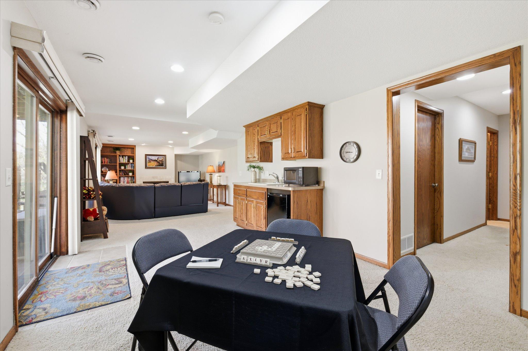 Retreat to the lower level where you'll find this huge amusement room with a wet bar area. Down the hall to the right is the 3/4 bathroom and utility room.