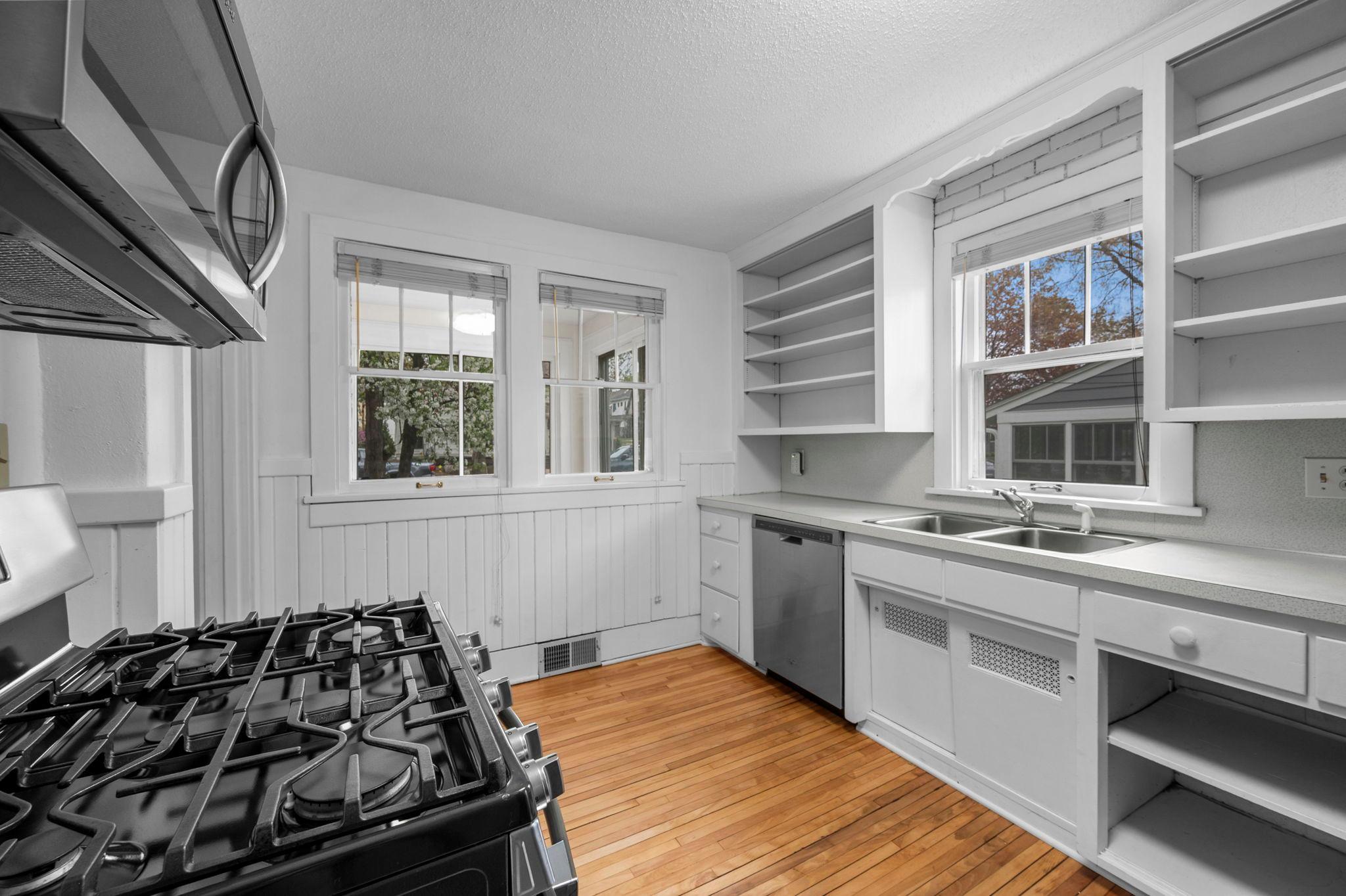 The walk-through kitchen features generous cabinetry, counter space, and a large pantry closet for practical everyday living.