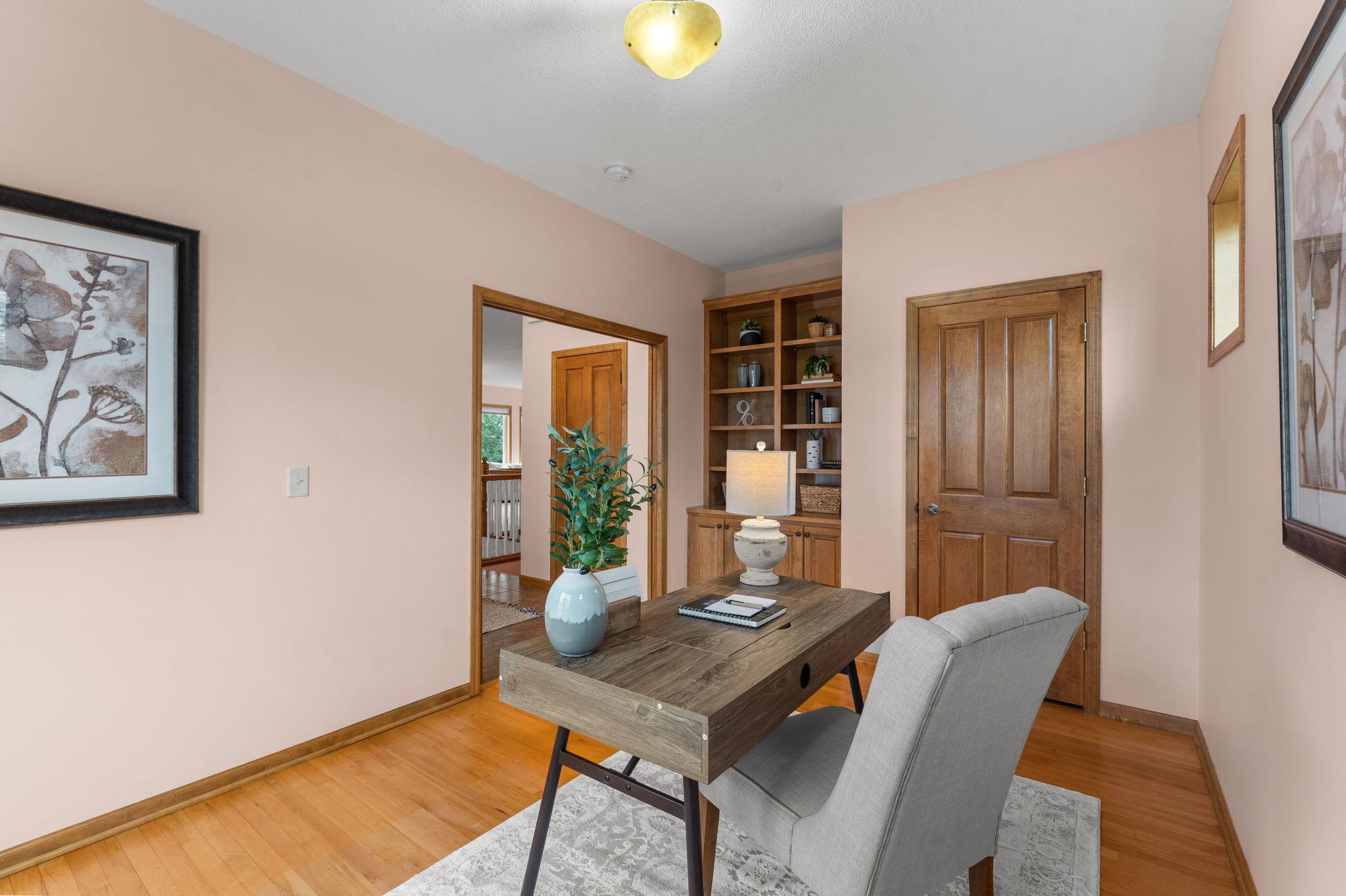 The second bedroom can also serve as a home office or den, featuring pocket doors, hardwood flooring, built-in shelving and cabinetry and ample closet space.