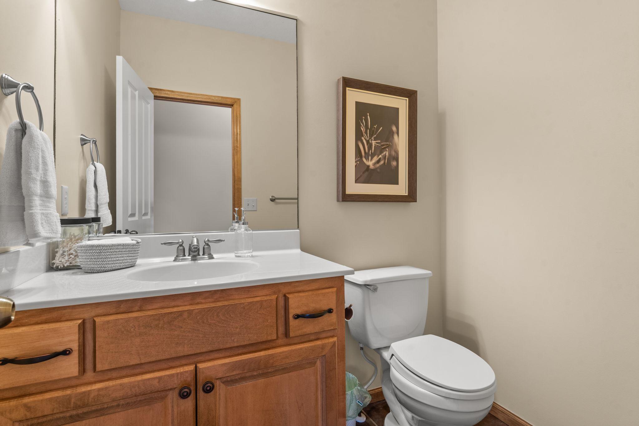 Just off the living room is a convenient half bathroom with tile floors and single vanity.