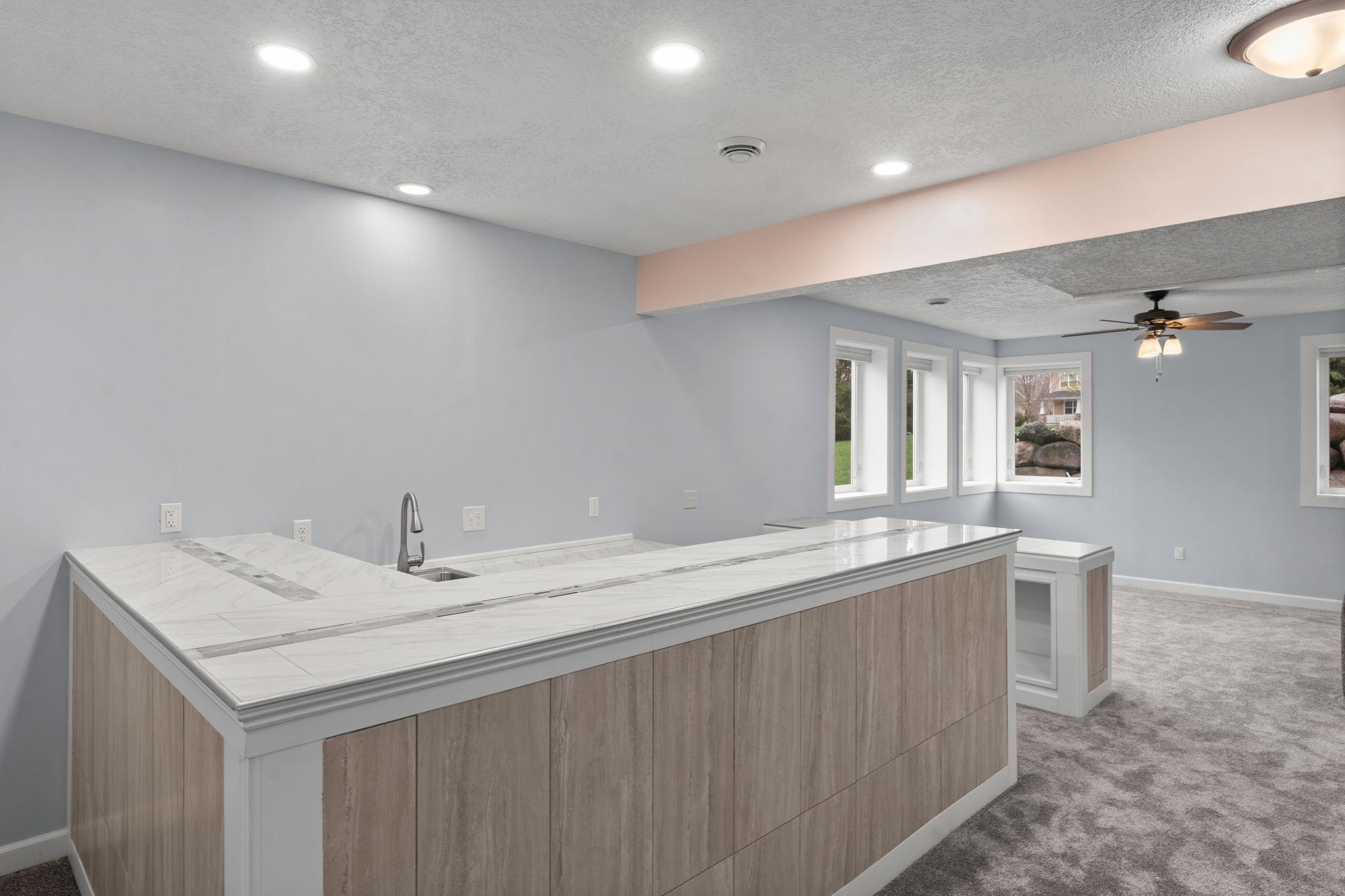 Adjacent to the family room is a wet bar with sleek countertops and a sink, ideal for entertaining guests.