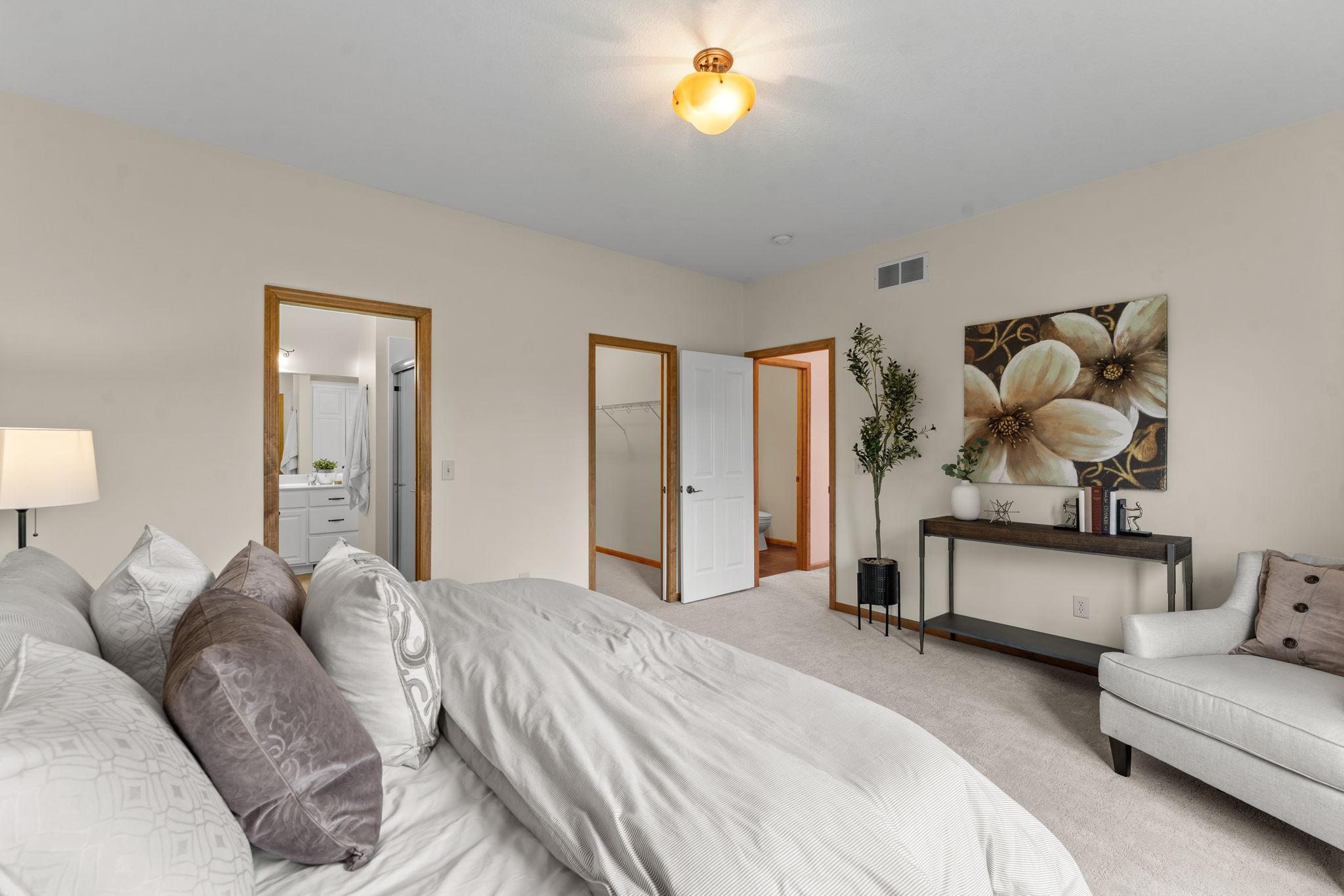 Another view of the primary bedroom, showcasing the entrance to the walk-in closet and private en-suite bathroom.