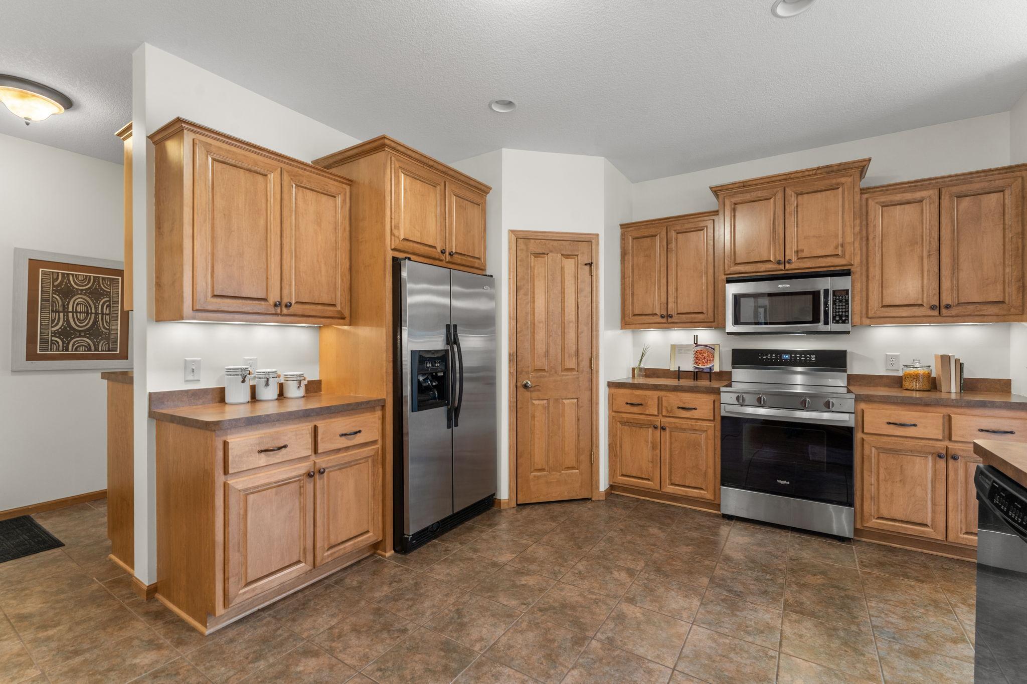 Another angle of the stunning, spacious kitchen, highlighting access to the hallway leading to the main-level laundry room and attached two-car garage.