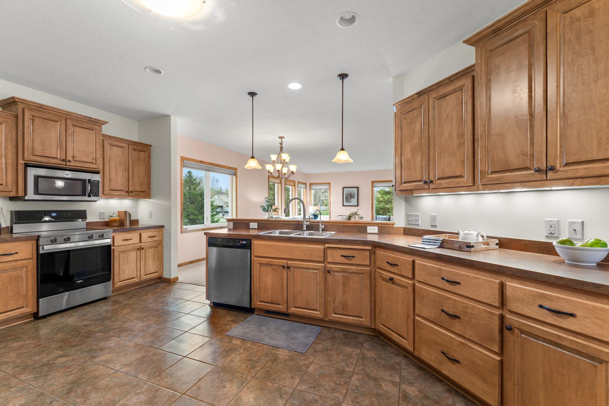The standout kitchen features tile flooring, abundant wood cabinetry, expansive counter space, stainless steel appliances and a 4x4 walk-in pantry.