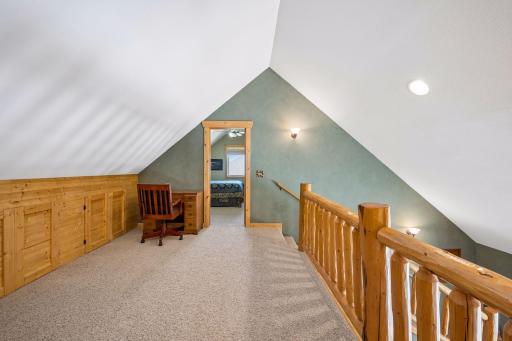 View of built in storage along wall and towards 2nd bedroom as you come up the stairs.