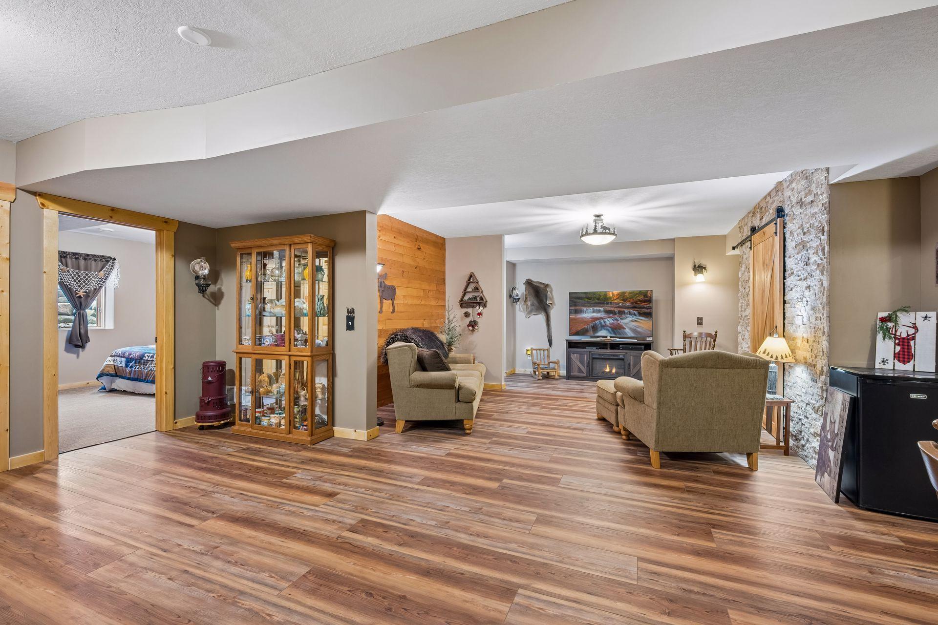 View of the lower level from back wall. Tall ceiling, additional bedroom, bathroom, storage room and more.