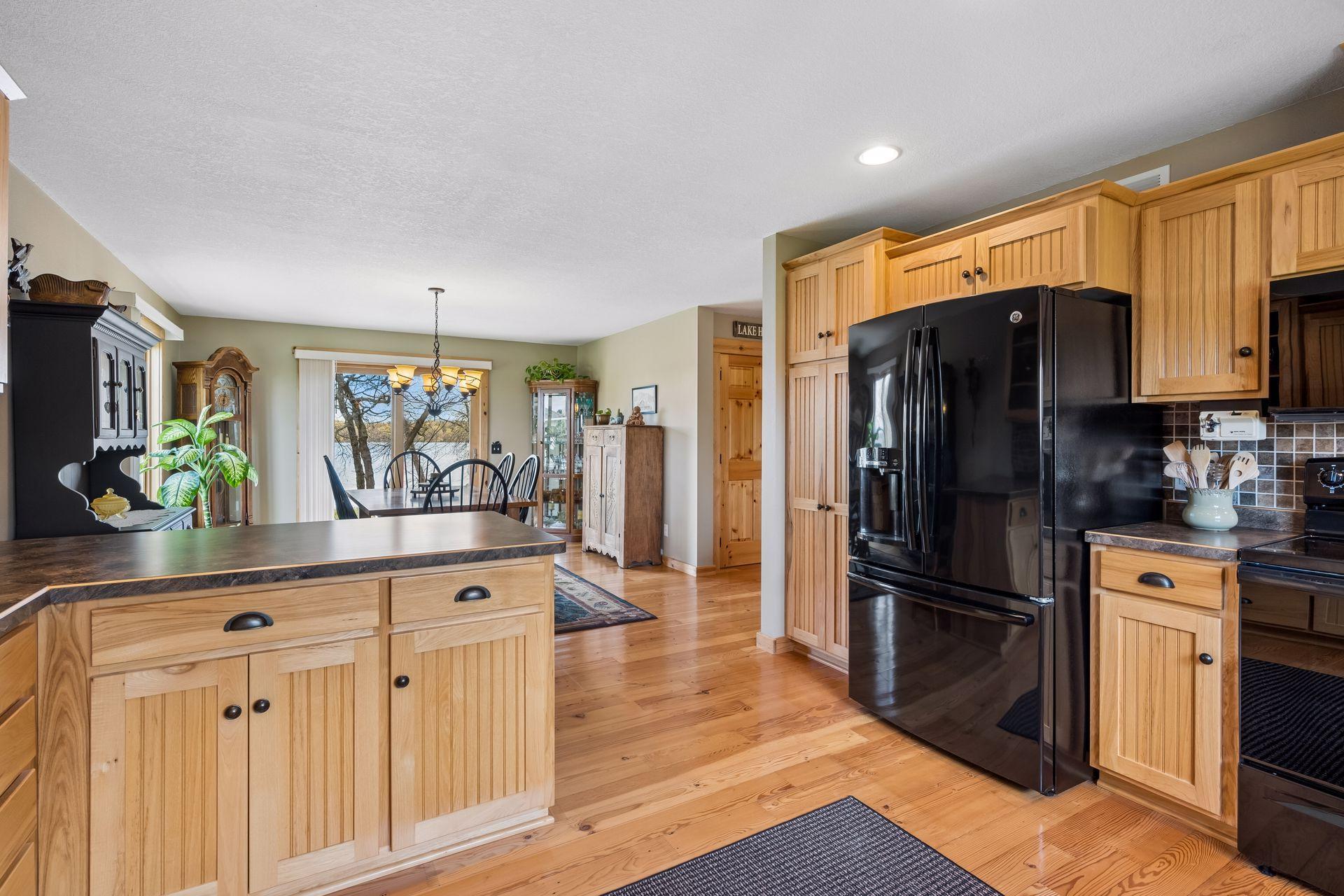 Open layout flows to dining area with scenic views, creating a comfortable, functional space perfect for gathering, cooking, and everyday living all while taking in the views of the lake and outdoor nature setting.