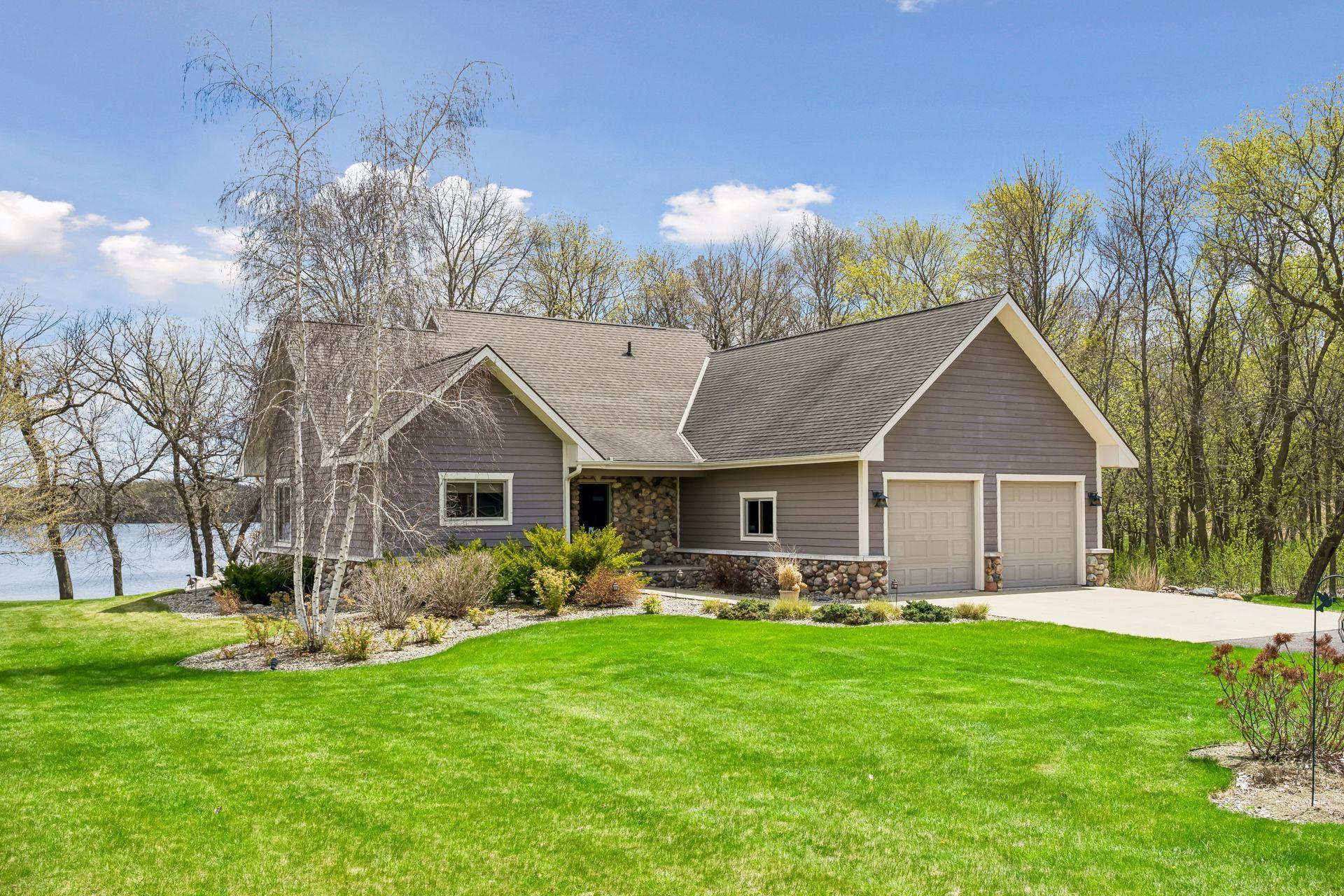 Side view of home showing stone surround accents on the home along with front concrete driveway area.
