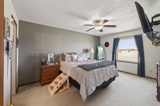 The upper level primary bedroom is generously sized with carpeting, abundant natural light, and a ceiling fan for year round comfort.