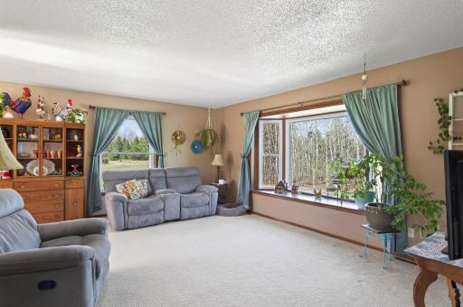 The upper level boasts neutral tones and abundant natural light, highlighted by an expansive bay window and additional large windows.