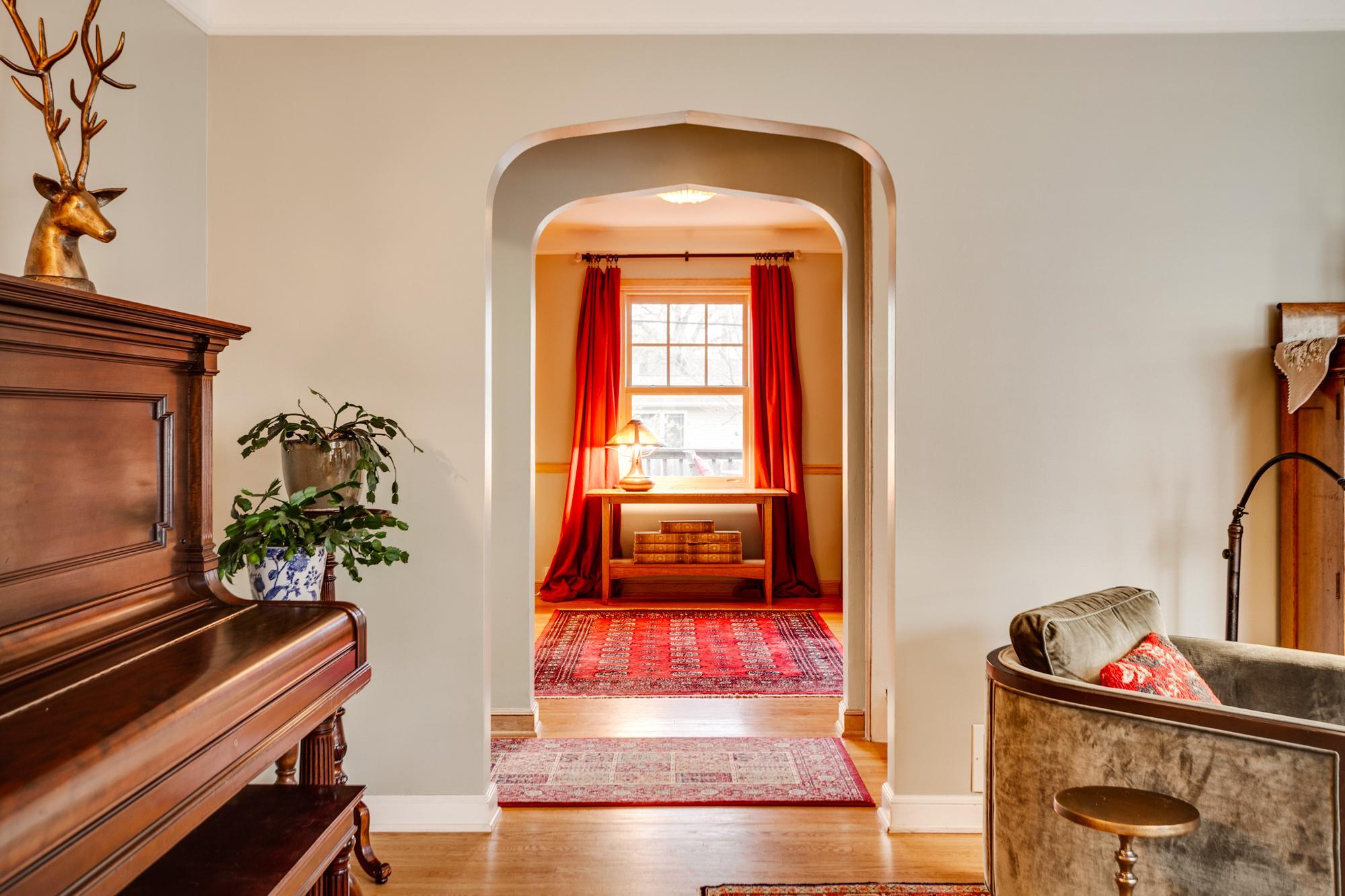 Elegant, coved ceilings and arched openings add architectural charm, creating a seamless flow from the living room to the formal dining room.