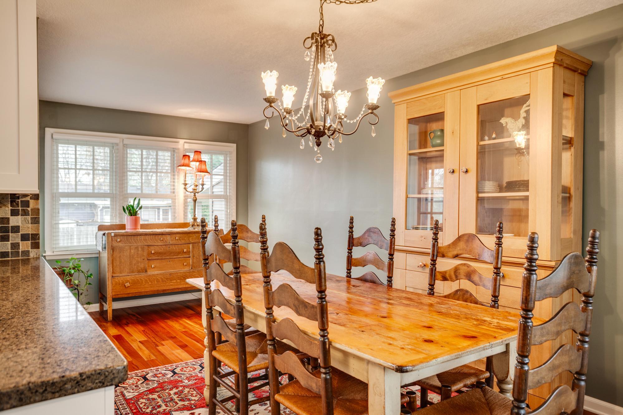 The adjoining informal dining area features excellent everyday dining space and is flooded with natural light from large windows on both ends of the room.