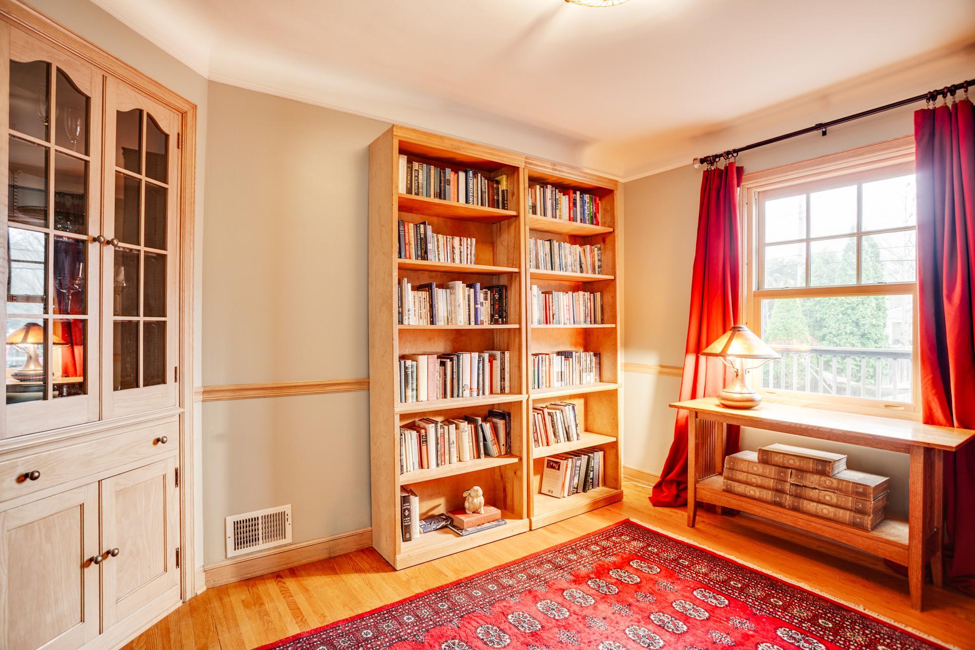 The formal dining room is a versatile space with built-in hutch, currently serving as a cozy library.