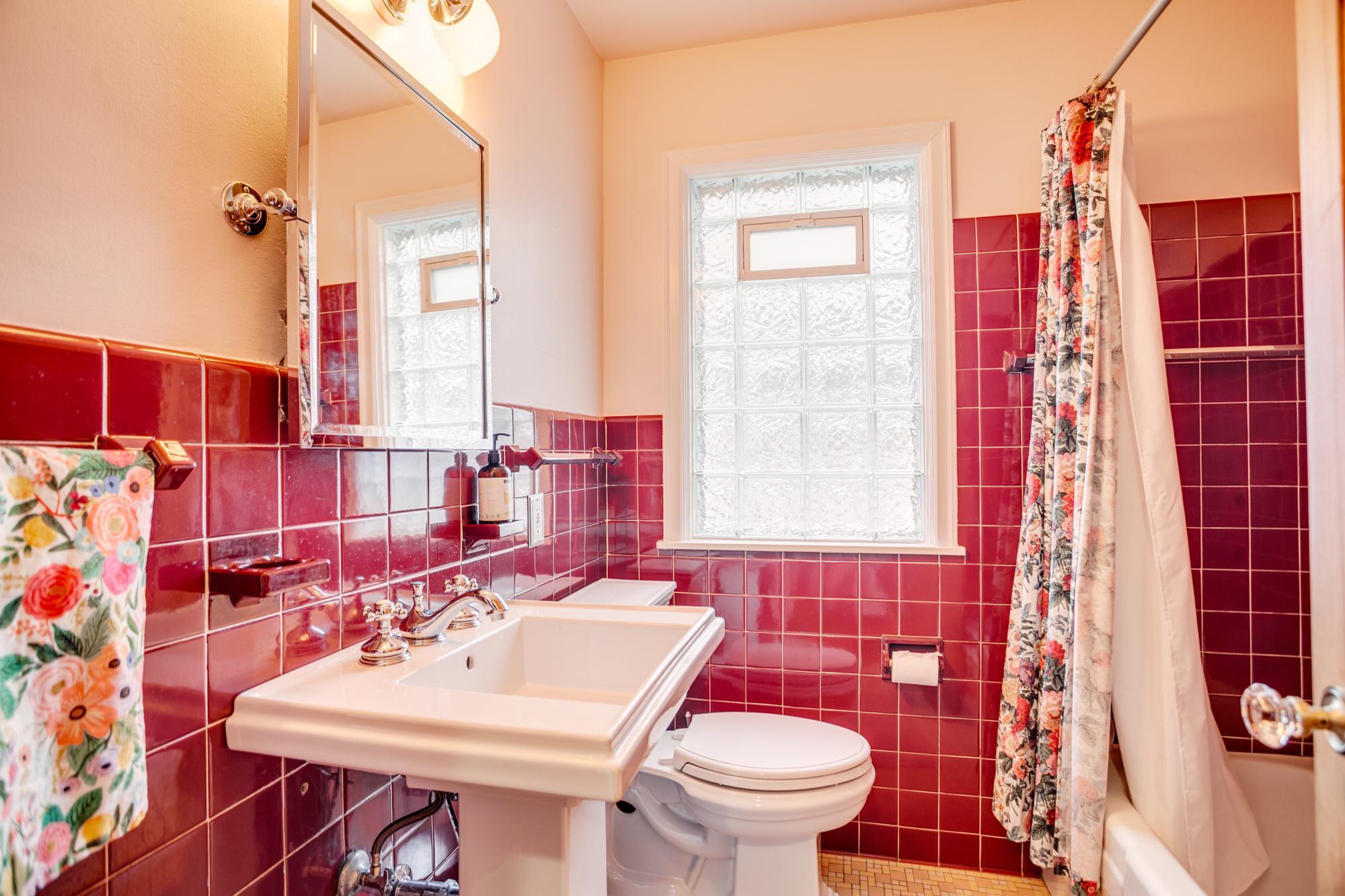 The two main level bedrooms are conveniently served by a nearby full bathroom, highlighted by classic tilework & glass block window.