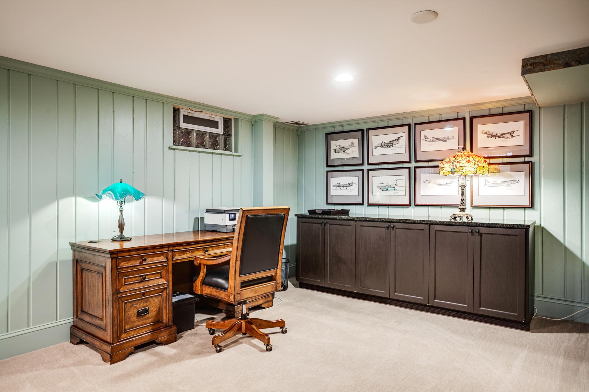 The adjoining flex space, currently used as a home office, offers versatility for a variety of uses, including a workspace, hobby area, or game table setup.