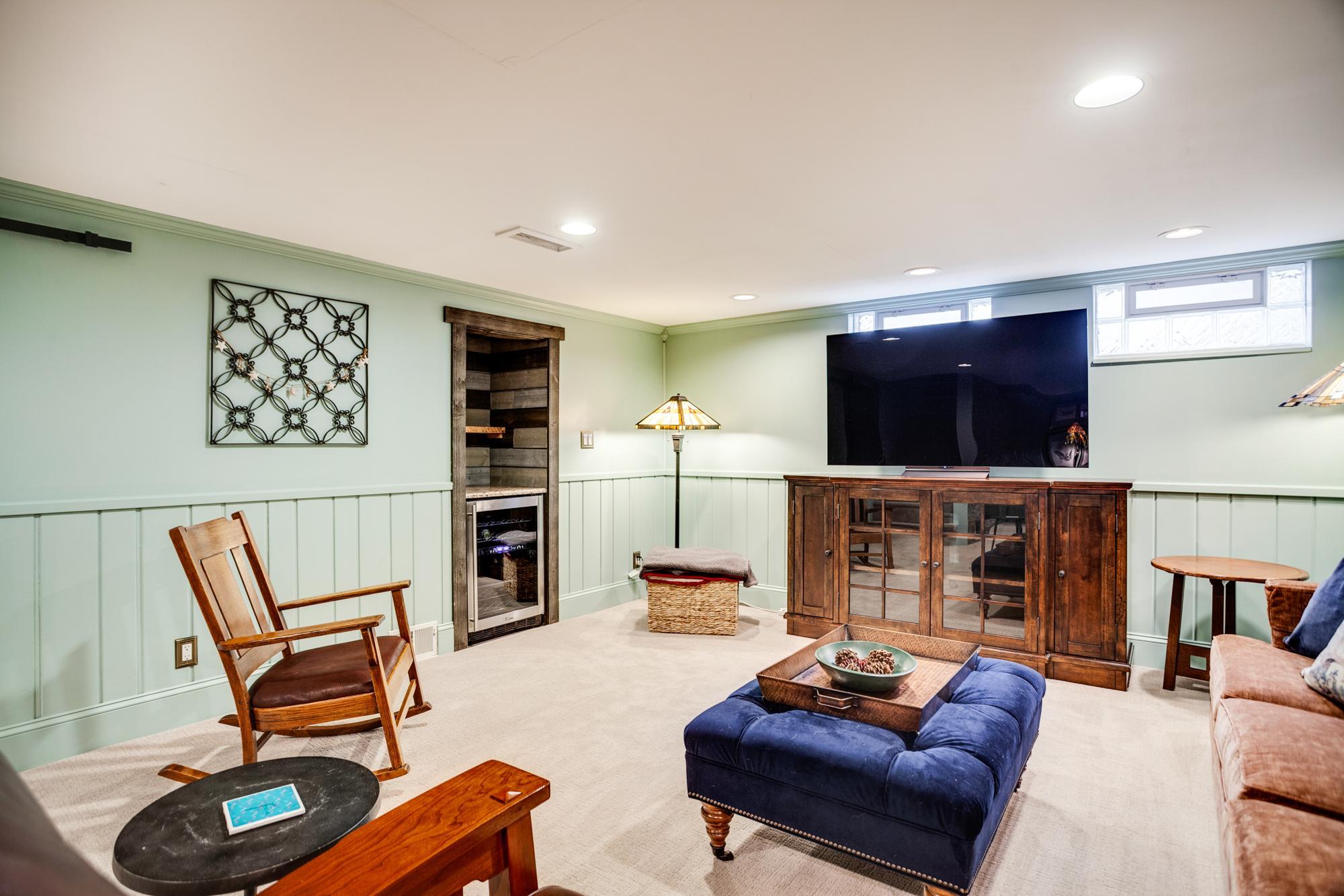 The spacious and inviting family room is perfect for relaxing, while a built-in dry bar with a beverage fridge adds convenience when entertaining. Added highlights include shiplap wall accents and glass block windows for fantastic natural light