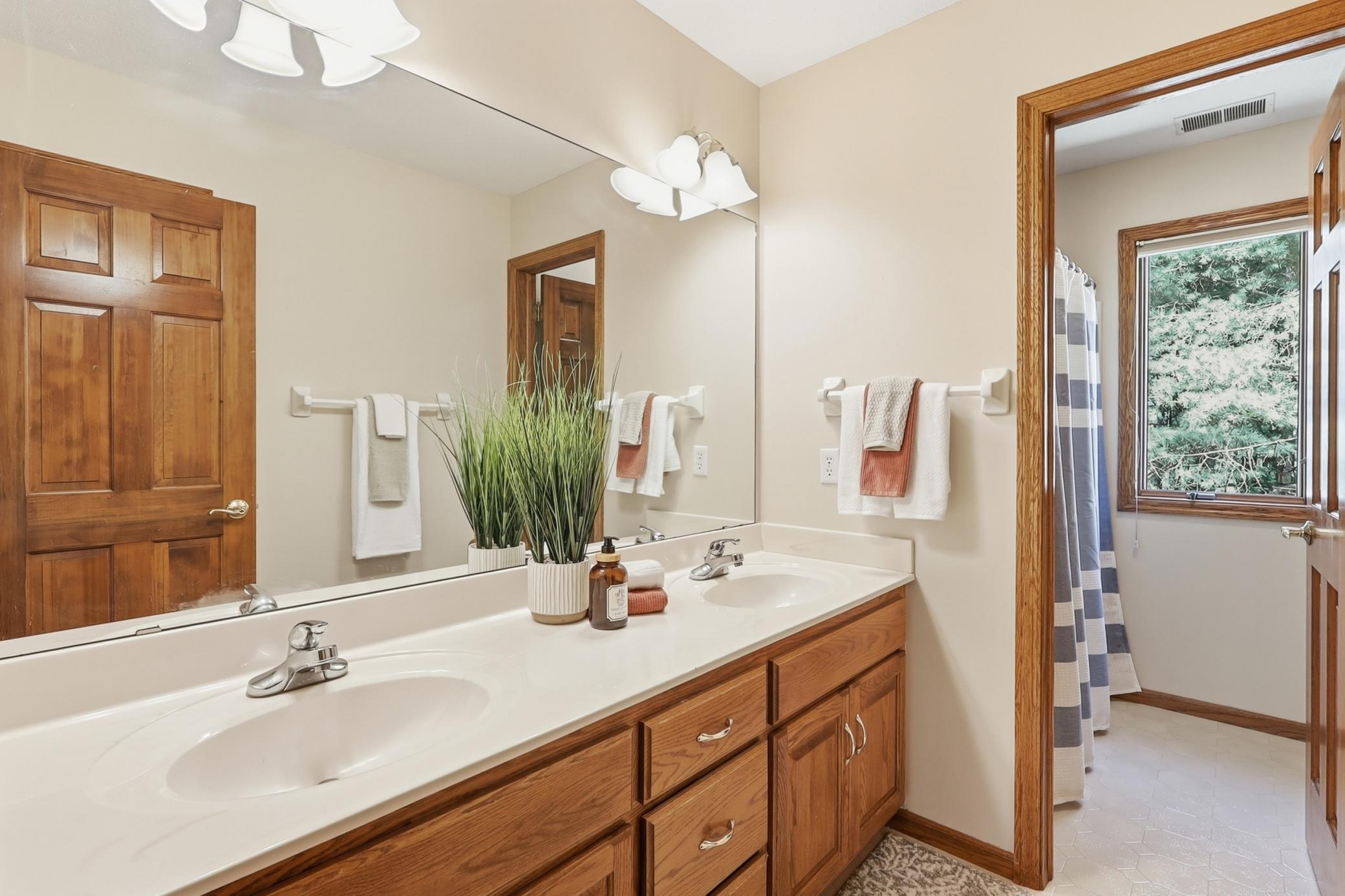 Upstairs Full Bathroom with double sinks and separate door to shower/bath and toilet