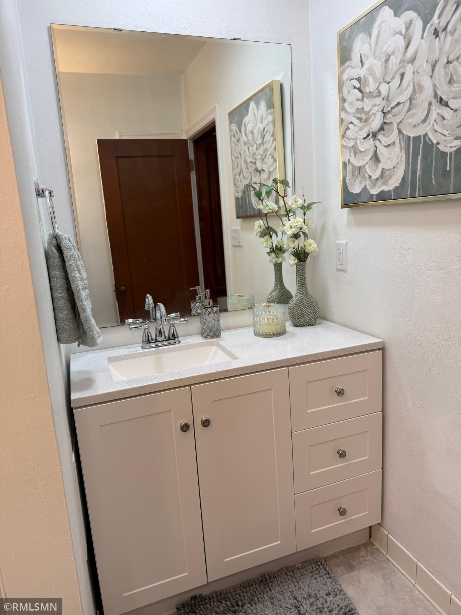 This bathroom is clean, bright and tastefully updated. It includes a tub shower combination with tile flooring that is both stylish and easy to maintain.