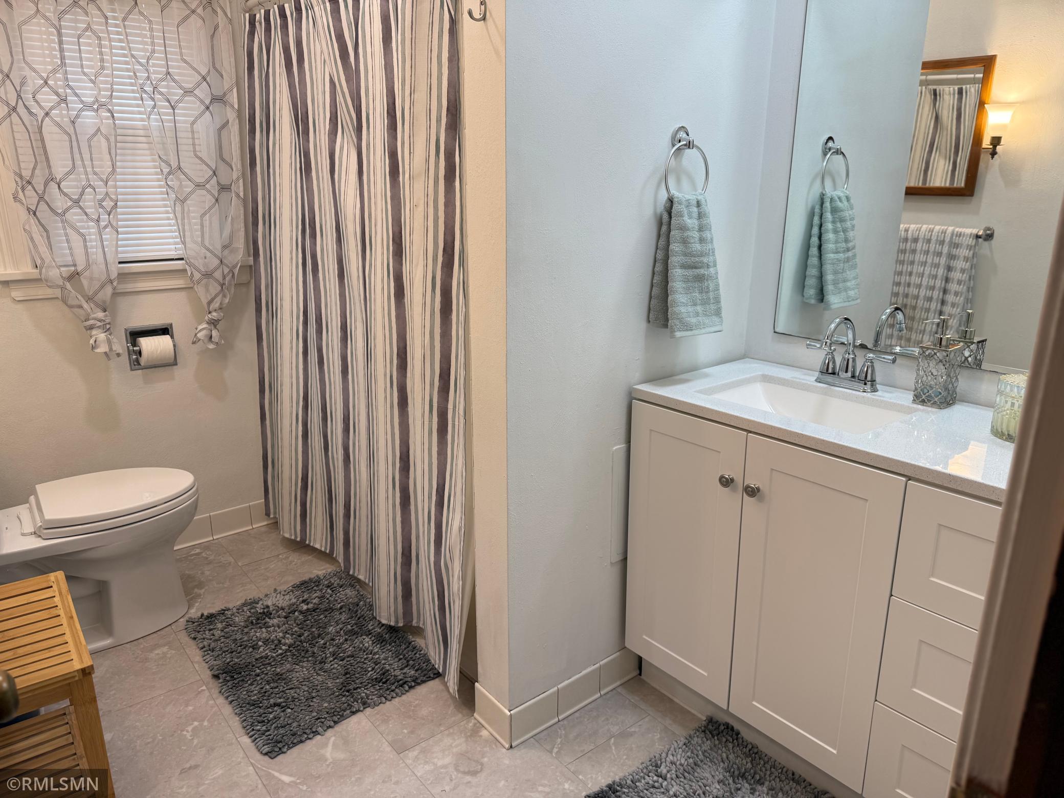 The window brings in some great natural light creating a warm and airy feel throughout details this neutral color politic make this bathroom, move-in, ready and easily to personalize