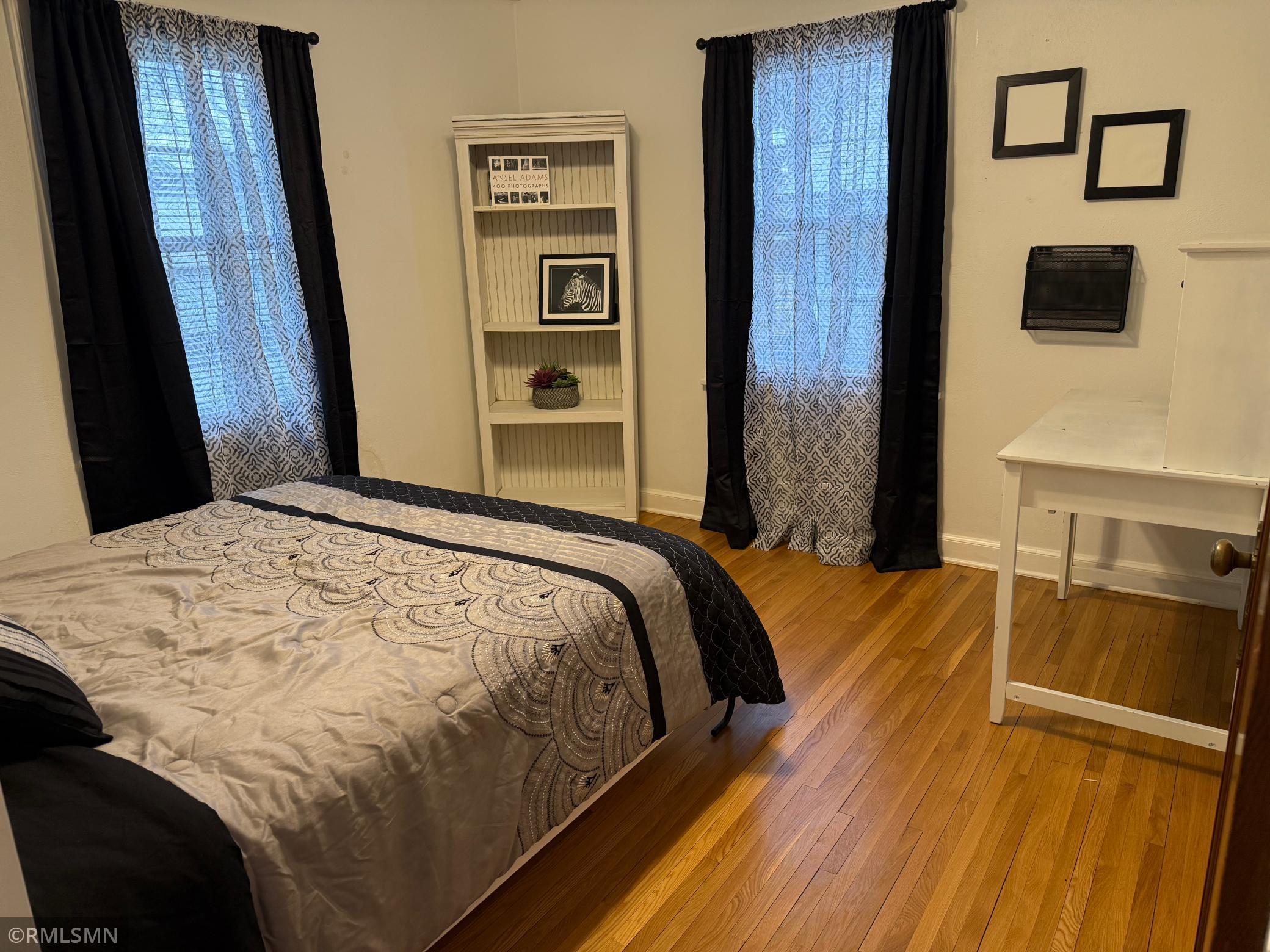 Comfortable and inviting this main level bedroom features, beautiful hardwood floors, bright neutral, color, palette that creates warmth and relaxing atmosphere. Outfitted with a Murphy bed for versatility to be bedroom or office