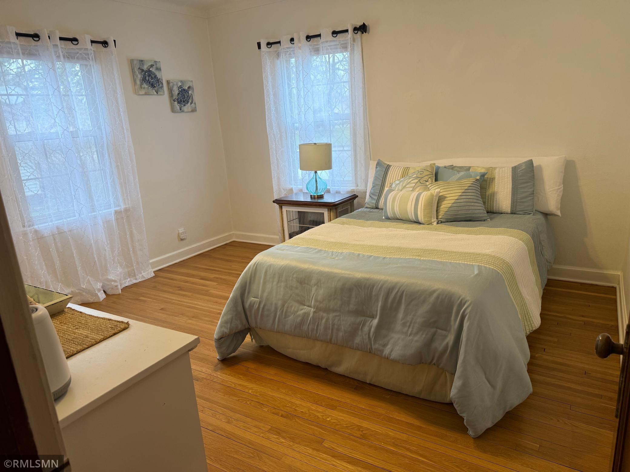 The windows in this bedroom make for great natural light color pallet is calm and Anne And inviting