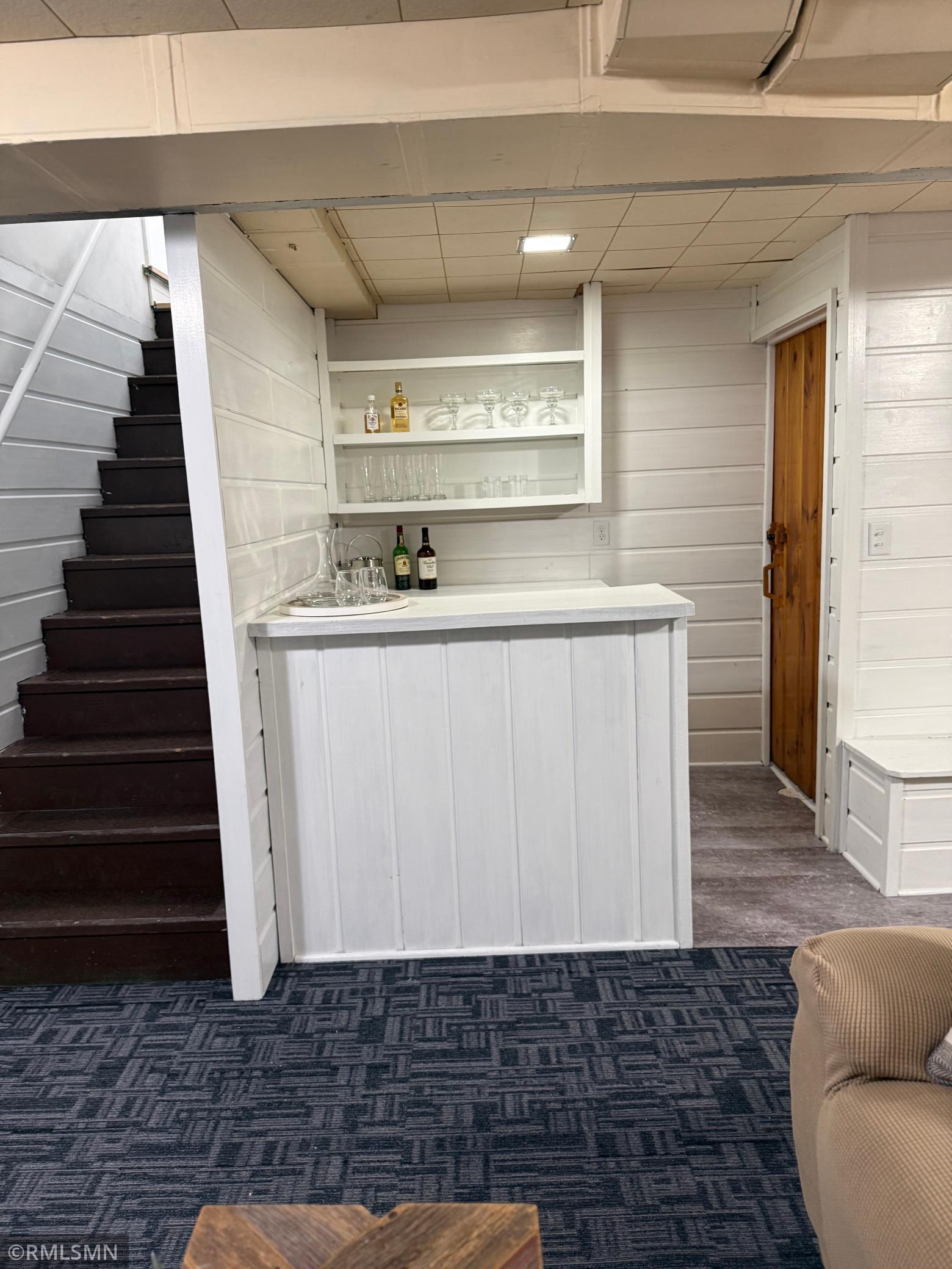 A charming built-in bar area with open shelving ads, both style and convenience, ideal for entertaining guests or creating a fun hangout space