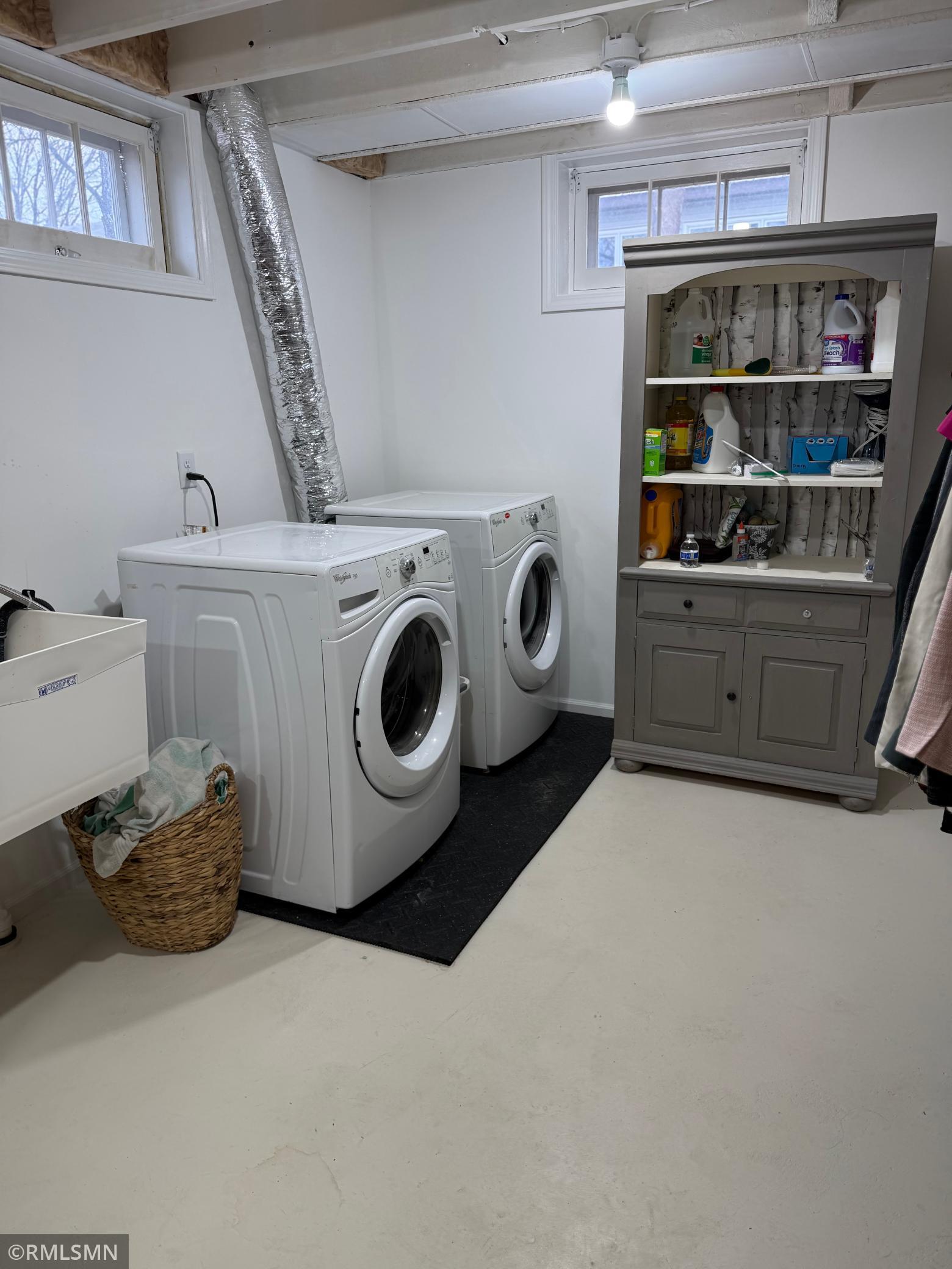 Functional and spacious this lower level utility area offers, convenient combination of laundry and storage space featuring washer and dryer along with utility sink. This area is designated for everyday ease and efficiency.