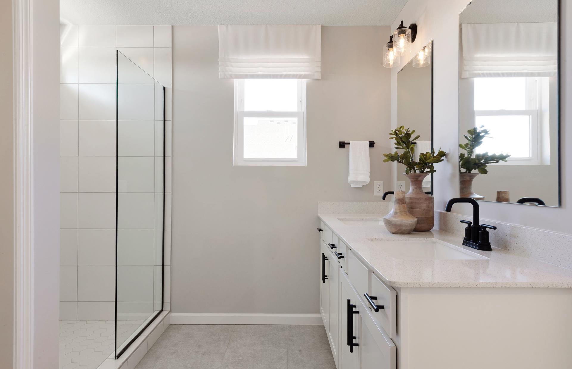 Perfectly located off the bedroom is the Primary Bathroom. This bathroom features modern finishings such as white cabinetry with quartz countertops mixed with the comfort of your double sink vanity and roomy shower. Photo of model home.