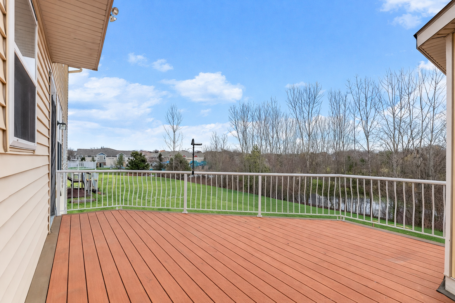 maintenance-free deck with stairs leading to the private backyard and pond