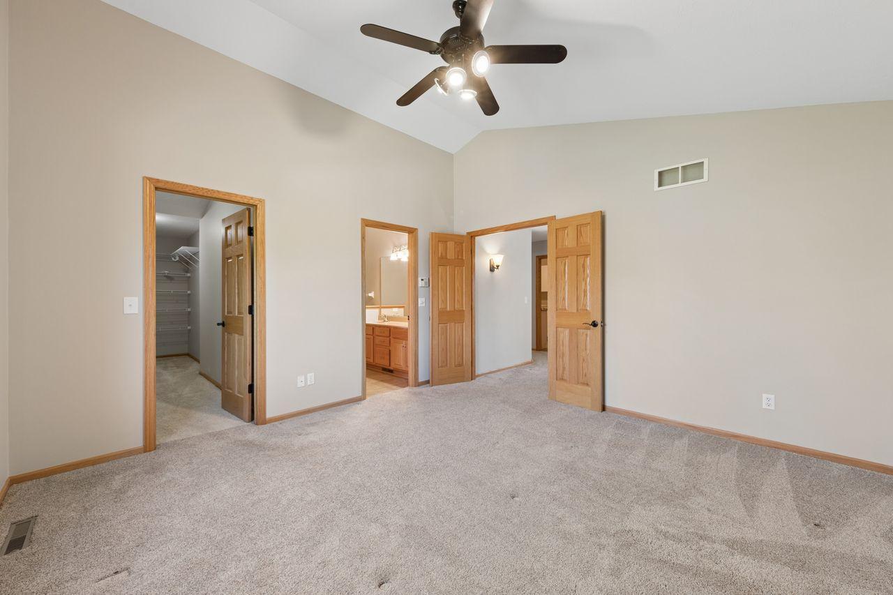 The primary suite features a vaulted ceiling, large walk in-closet and tiled walk-in shower.