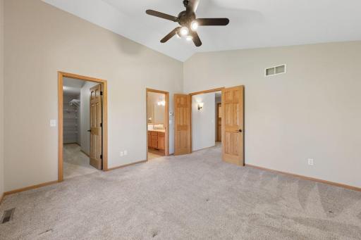 The primary suite features a vaulted ceiling, large walk in-closet and tiled walk-in shower.