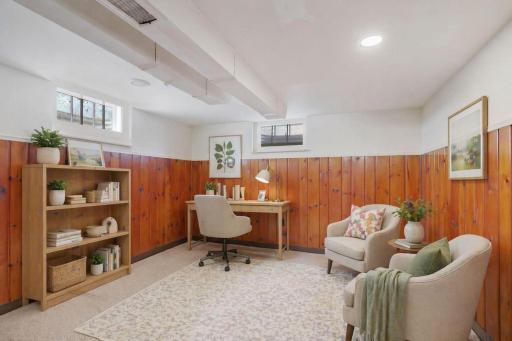 Bonus room at lower level is virtually staged here as a study. Future potential to change to a conforming bedroom with egress window. The genuine wood panels warm the space.