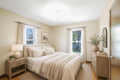 Gorgeous hardwood floors & millwork with large, daylight windows in this first bedroom on main level. There is a Nest Thermostat for the Homeowners' ability to control remotely. This is virtually staged.