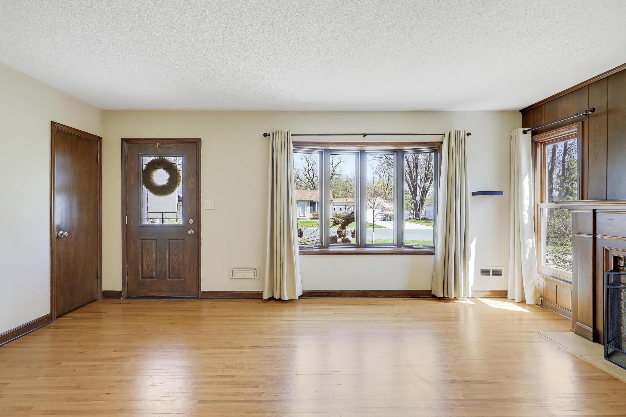 Huge bay window and solid front door with glass detail add light and loveliness.