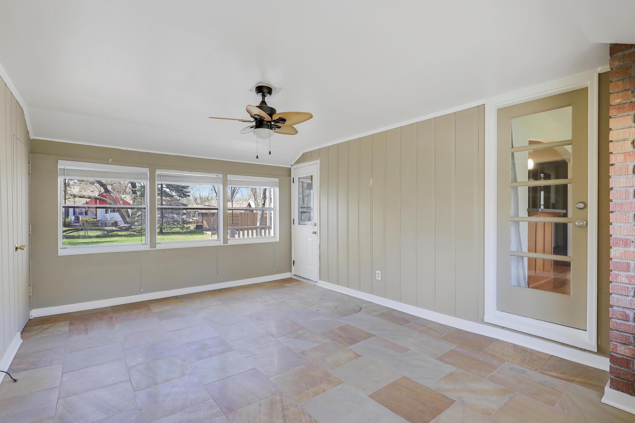 Breezeway/Sunroom connects the living room, kitchen, deck and garage. Notice the large tile floors in neutral tones. This is a suitable space for a potluck brunch or just lounging with friends and family.