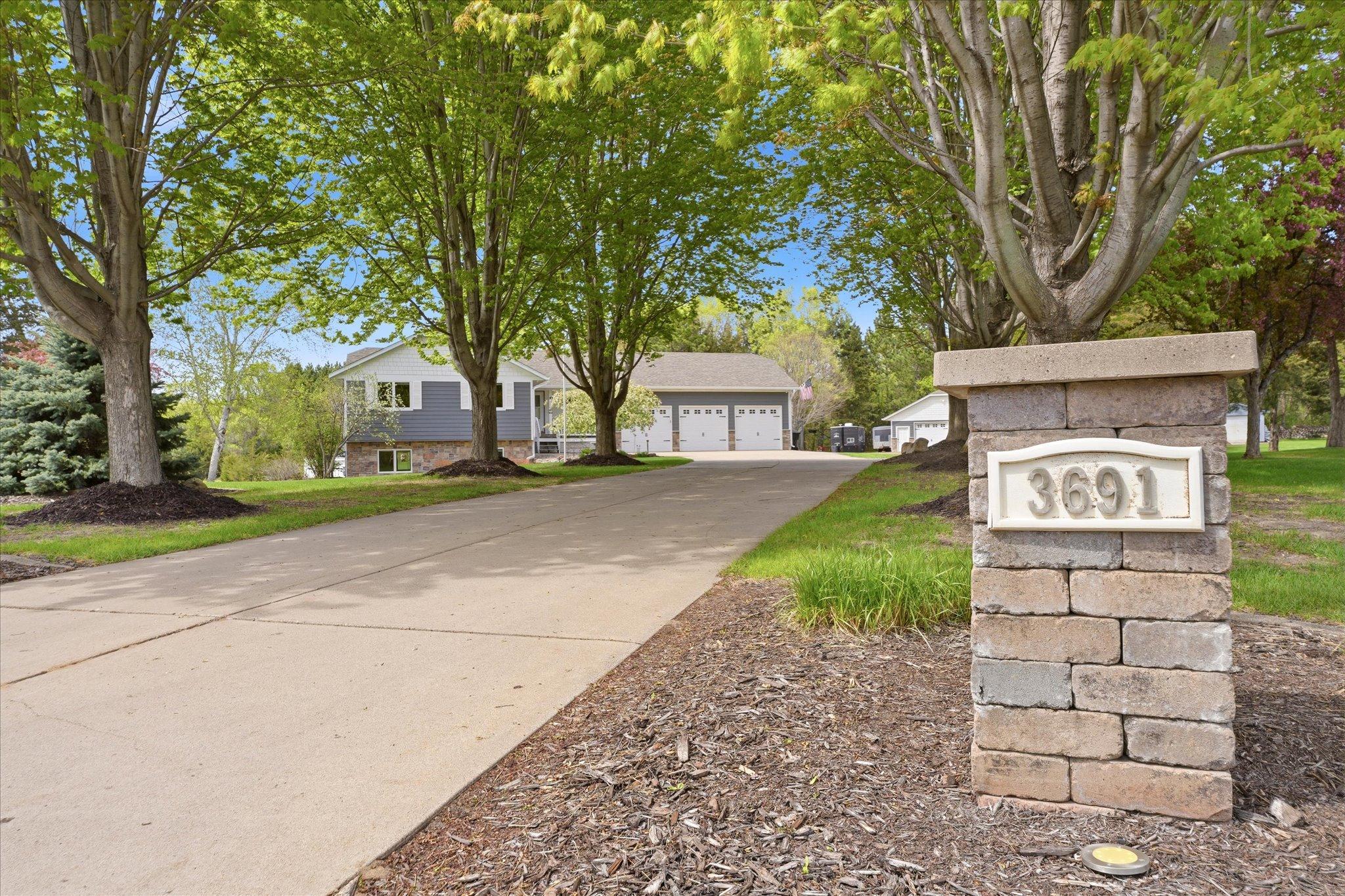 The maple-tree-lined driveway begins with a beautiful paver stone address monument, just to be sure you're in the right place.