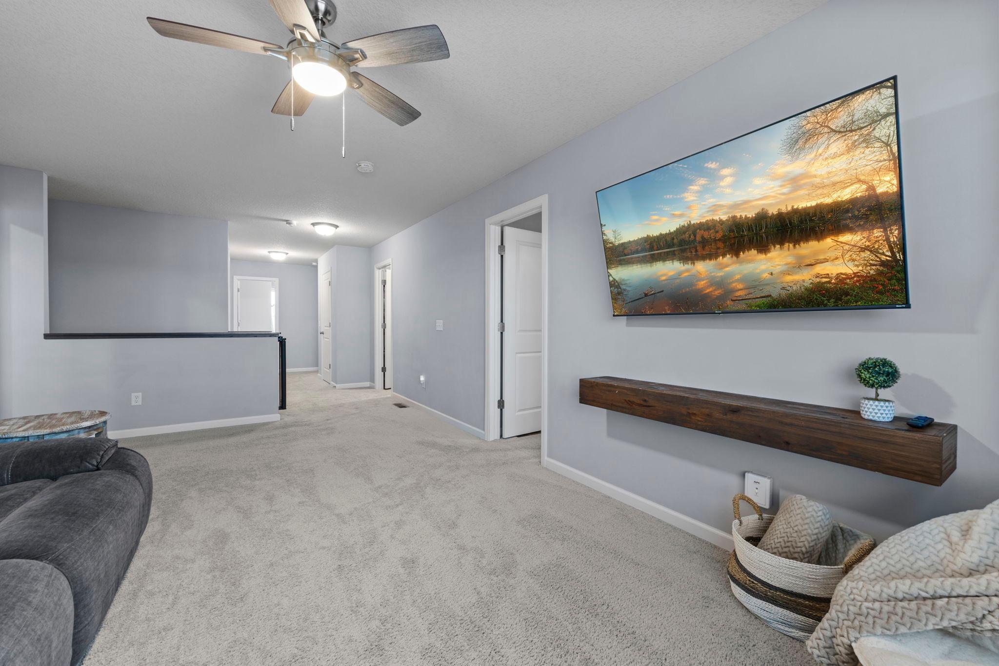 Upper-level loft with built-in shelving, ceiling fan, and tinted window is another space to gather and relax!