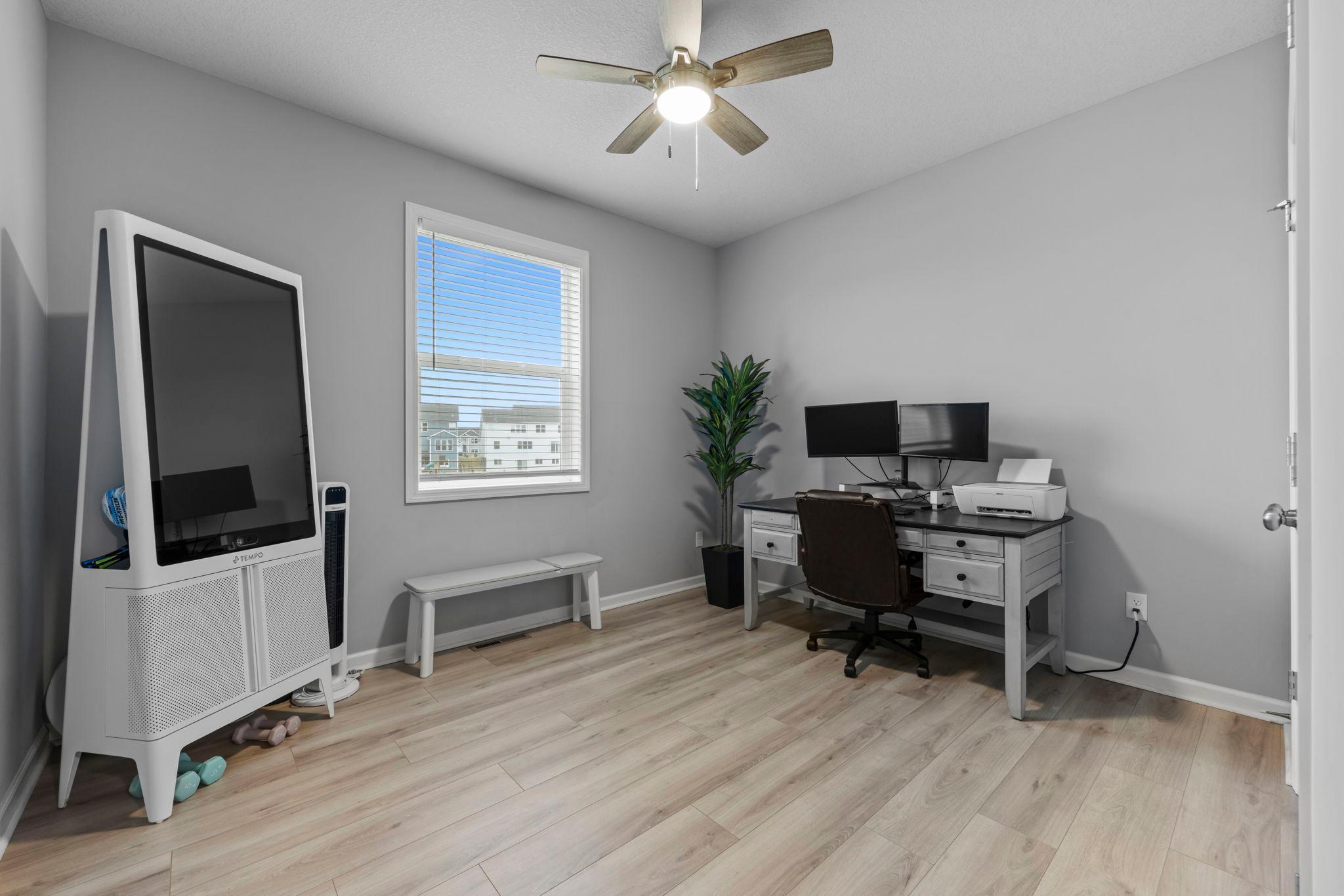Main Floor Bedroom with tinted window, ceiling fan, and new flooring. Immediately off of the mudroom and living room for a privacy.