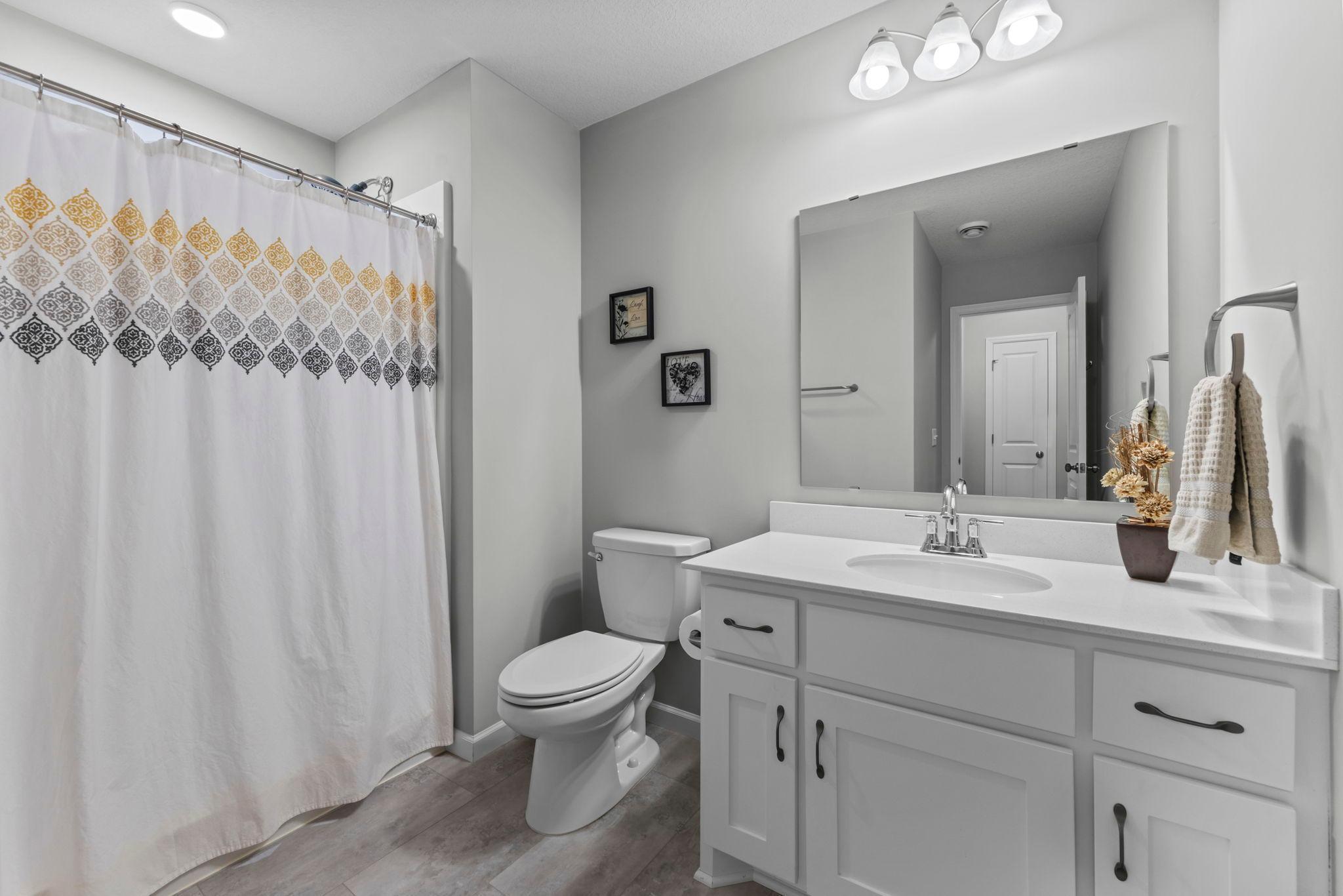 LVT flooring with Corian countertops, soft close drawers, & 3/4 walk-in shower