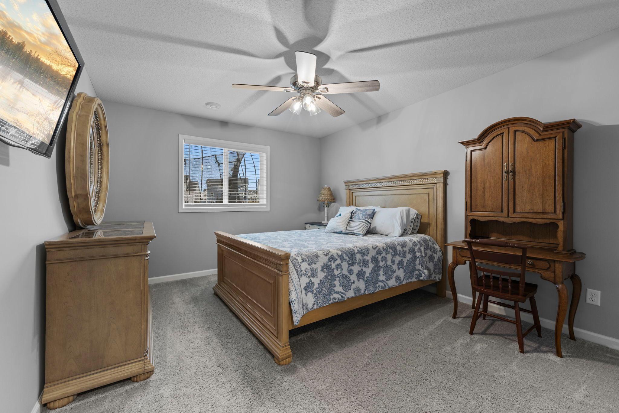 Lower-level bedroom with walk-in closet and ceiling fan