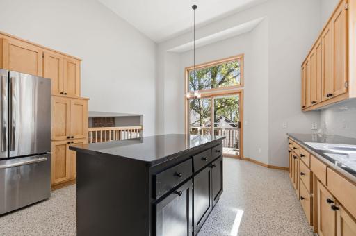 A large center island is complemented by additional space for a kitchen table.