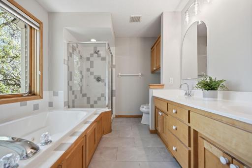 The ensuite features a jetted tub, double vanity, and walk-in shower.