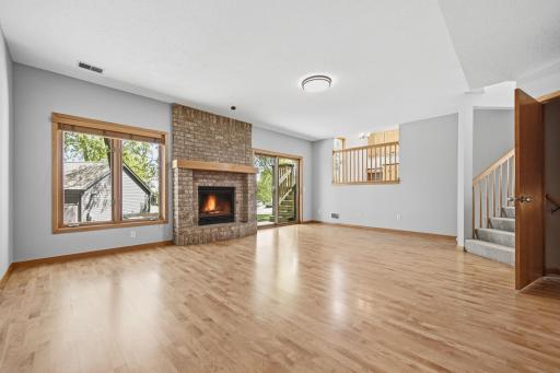 Step down into a cozy secondary living space featuring a fireplace and deck access.