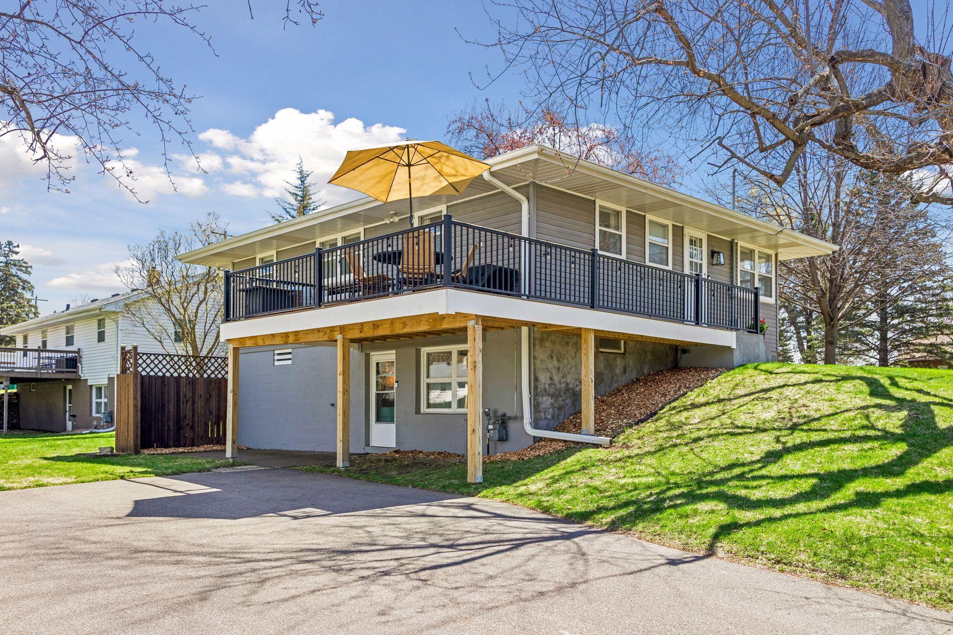 Exterior view showcasing the wraparound deck and yard.