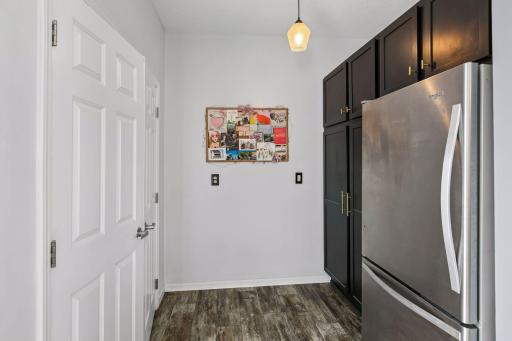 View of extension of kitchen with refrigerator, additional storage, and laundry.