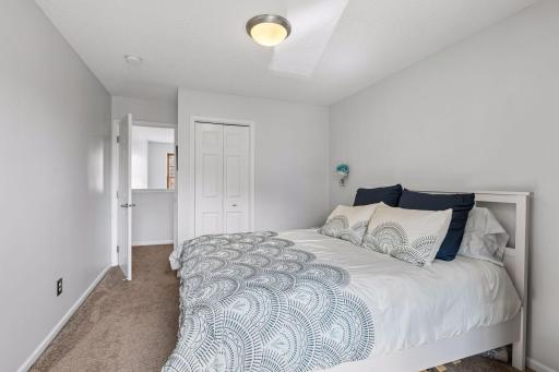 Bedroom one with view of the closet and the door to hallway and the stair down to main level.