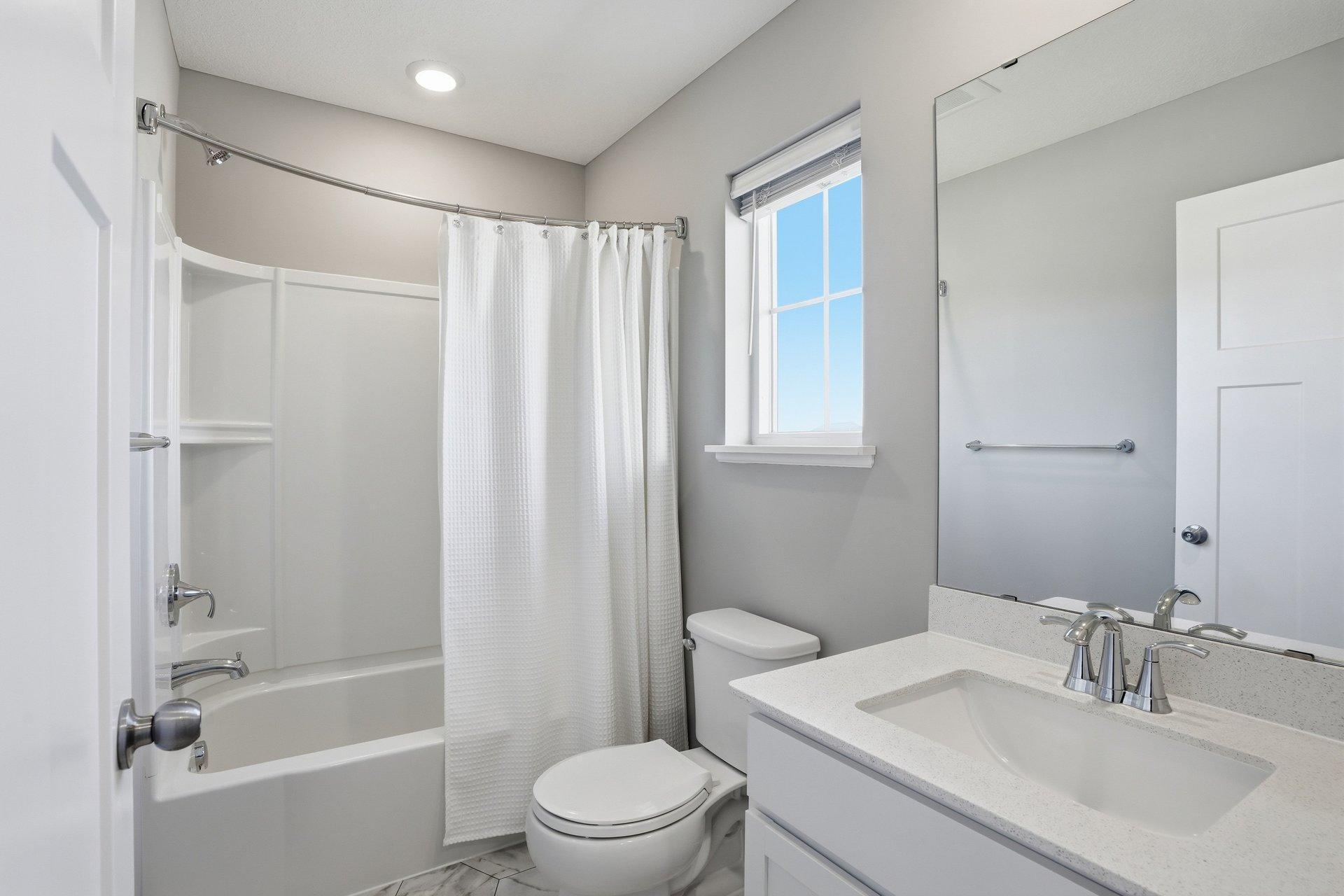 Full hall bathroom with shower/tub combo for children or guests.