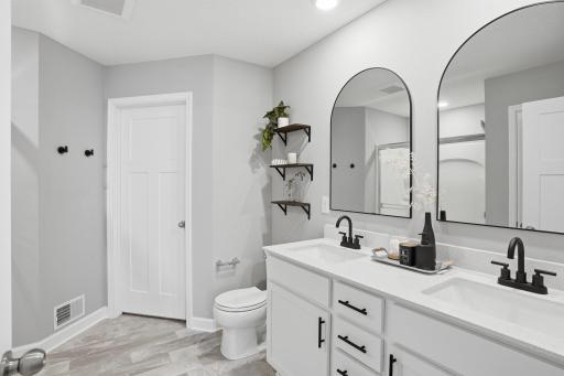 Primary ensuite has double sinks, walk-in shower and fresh black fixtures including new mirrors.