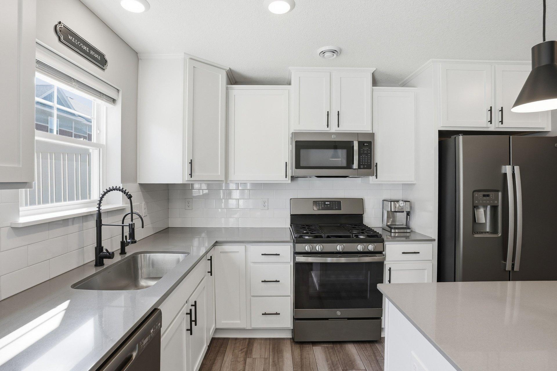 Slate-finish appliances including gas stove and double door fridge with waterline.