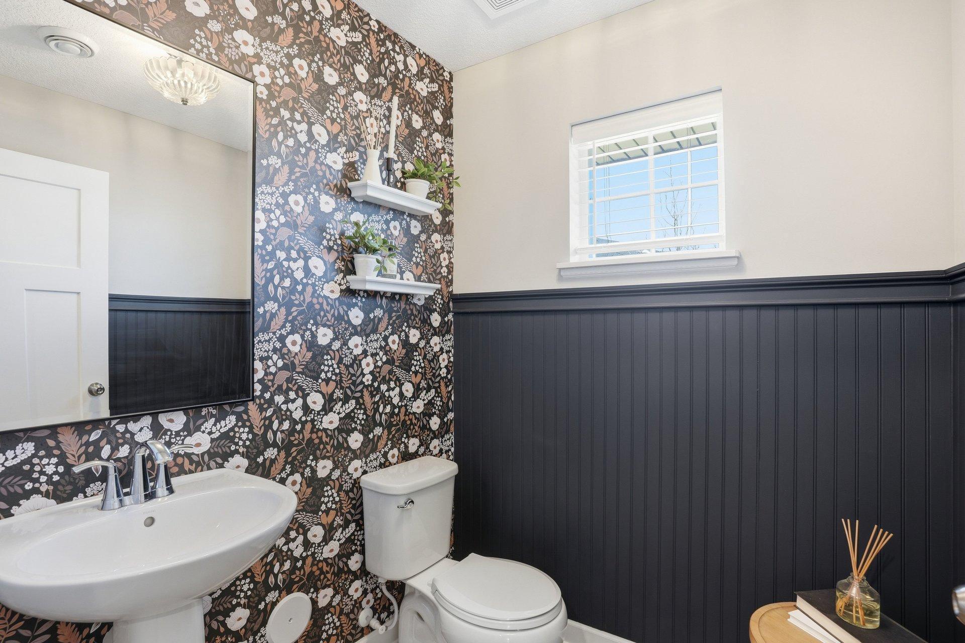 Main level powder bath with custom wainscoting, wallpaper and designer finishes.